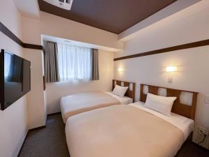 东京The OneFive Tokyo Shibuya的酒店客房设有两张床和一台平面电视。
