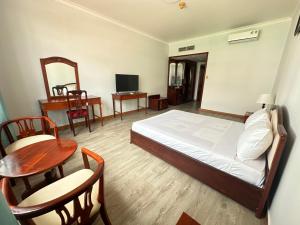朔庄NGOC THU HOTEL的卧室配有一张床和一张桌子及椅子