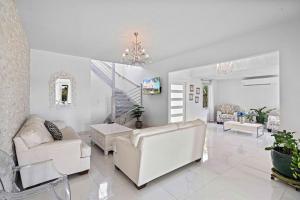 努尔德Caya Mesa Bista 40 Tierra del Sol的客厅配有白色家具和吊灯。