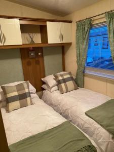 科克茅斯2-Bed Lodge in Cockermouth的两张床位于带窗户的房间内