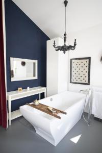 施库尔Chasa Alba的浴室配有白色浴缸和蓝色的墙壁
