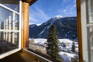 RamoschChasa Schilana 84的窗户享有雪覆盖的山脉美景