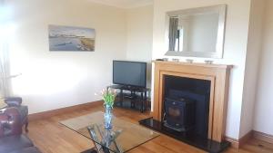 巴利康尼利Coral Strand Lodge的客厅设有壁炉和电视。