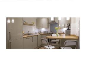 爱丁堡The Lane Apartment的厨房配有白色橱柜和桌椅