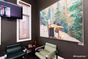 墨尔本Tolarno Hotel - Georges Suite - Australia的一间设有两把椅子的等候室和墙上的一幅大画