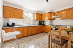 洛斯·亚诺斯·德·阿里丹Casa Maravillosa - Seaview的厨房配有木制橱柜和木桌。