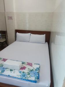 胡志明市Hotel Phương linh的一张位于小房间的床,配有白色的床上用品