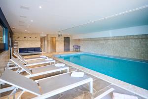 罗什福尔麦尔博斯特酒店的一个带躺椅的酒店客房游泳池