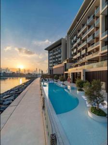 迪拜Hyatt Centric Jumeirah Dubai - King Room - UAE的一座大型建筑,在水边设有游泳池