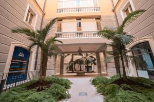 莱切Davids Room Palazzo Tamborino的两棵棕榈树的建筑