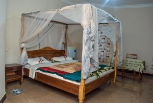卡拉图KLH REST HOUSE的一间卧室,卧室内配有一张天蓬床