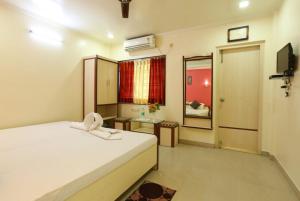 迪卡Hotel Mira international - Luxury Stay - Best Hotel in digha的卧室配有白色的床和镜子