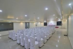 迪卡Hotel Mira international - Luxury Stay - Best Hotel in digha的一间设有一排白色椅子和屏幕的房间