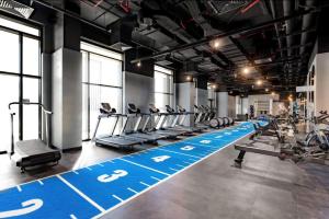 迪拜Hyatt Centric Jumeirah - Dubai Twin Room - UAE的健身房,有健身者在跑步机上锻炼