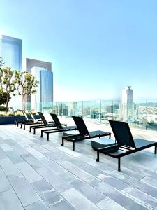 洛杉矶Relax On The Penthouse Floor DTLA With A View的坐在大楼顶上的一排椅子