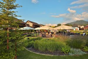 利普托斯基米库拉斯Hilson Jasna - Garden resort的一座带桌子和遮阳伞的花园