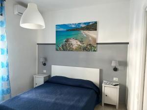 卡梅罗塔码头Mareluna Bed and Breakfast的一间卧室设有蓝色的床和海滩