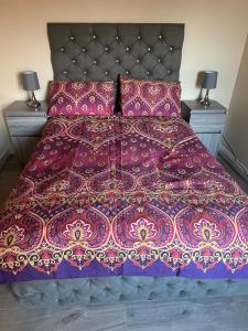 斯劳ELSARO guest house的一张带紫色棉被和两盏灯的床