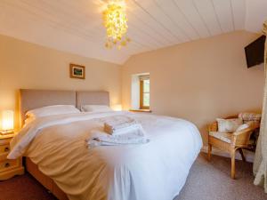 Lydbrook2 Bed in Lydbrook 55961的卧室配有一张白色大床和吊灯。