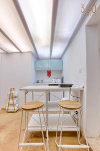 拉巴特Authentic & cosy duplex home in charming Rabat By 360 Estates的厨房配有2张凳子和1个白色的台面