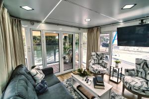 Merritt IslandBrand New House Boat Stunning Views and Resort Amenities的客厅配有沙发、椅子和电视