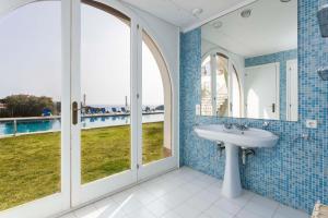 桑特费柳德吉克索尔斯Villa Maricel的设有带水槽的浴室,享有游泳池的景色