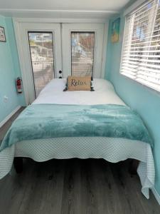 Merritt IslandSeaside Escape A Cozy Houseboat的一张大床,位于带两个窗户的房间