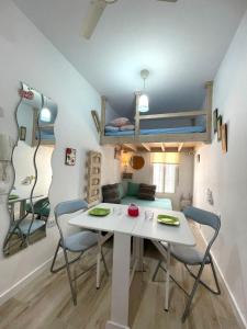科尼尔-德拉弗龙特拉PRECIOSO Y PEQUEÑO LOFT CENTRO DE CONIL的客房设有桌椅和一张双层床。