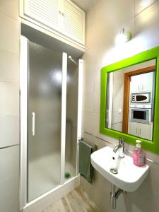 科尼尔-德拉弗龙特拉PRECIOSO Y PEQUEÑO LOFT CENTRO DE CONIL的一间带水槽和绿色镜子的浴室