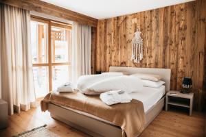 安泰塞尔瓦·迪·梅佐Exzelent Residence的一间卧室配有带毛巾的床
