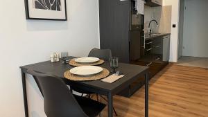 波恩Gallery Apartment的厨房里一张带椅子和盘子的黑桌