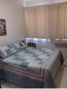 里贝朗普雷托Flat Bassano Vaccarini的卧室配有蓝色和白色的格子床
