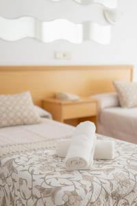 贝尼多姆Hotel Santa Faz的酒店客房的床上有两条毛巾