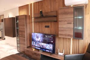 卡萨布兰卡LUXE APPARTEMENT的客厅设有木墙,配有电视。