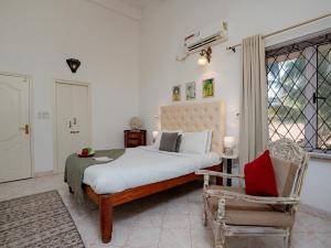 果阿旧城Echo - Classy 3bhk Villa - vagator的卧室配有床、椅子和窗户。