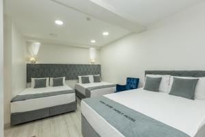 伯萨BURSA GRAND FAMİLY HOTEL & SpA的带三张床和蓝椅的客房