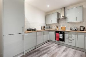 罗瑟勒姆Modern Studio Apartment in Central Rotherham的白色的厨房配有白色橱柜和电器