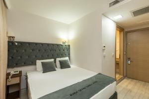 伯萨BURSA GRAND FAMİLY HOTEL & SpA的一间卧室配有一张大床和绿色床头板