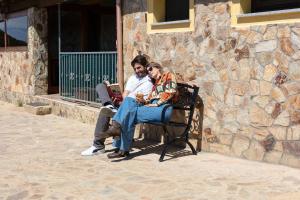 阿尔布斯奎拉旅馆的两个人坐在石墙旁的长凳上