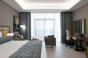 吉布提Djibouti Ayla Grand Hotel的酒店客房设有一张大床和一张书桌。