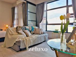 哥打京那巴鲁#1 Jesselton Quay City Pads Seaview by Zeluxo的带沙发和玻璃桌的客厅