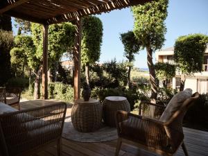 普莱诺斯Sentiero Iconic Villa, a Serene Retreat, By ThinkVilla的露台配有椅子和桌子,甲板上配有桌子