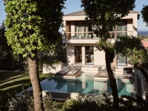 普莱诺斯Sentiero Iconic Villa, a Serene Retreat, By ThinkVilla的享有带游泳池和树木的外部景致