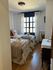 比努埃萨Apartamento Mirador del Pantano 1的一间卧室设有三张床和窗户。
