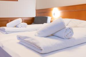 佩奇Szinbád Hotel的床上的3条白色毛巾
