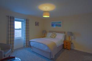 GarliestonThe Harbour Inn的卧室配有床、椅子和窗户。