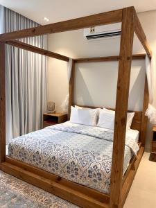 马斯喀特Water Front Villa BF108的一间卧室配有一张带木架的天蓬床