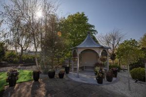利默里克Castletroy Park Hotel Suites的种植了盆栽植物的花园中的凉亭