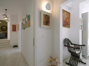 阿诺梅拉Chrysanthemo villas的走廊上挂有椅子和墙上的绘画作品