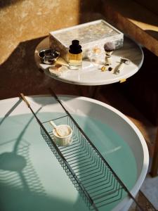 迪拜The Lana - Dorchester Collection的配有浴缸和水槽的玻璃桌